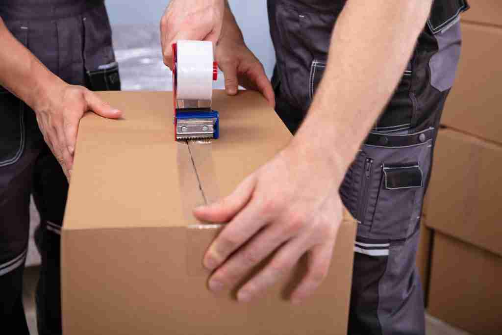 Olympia packers putting tape on a box